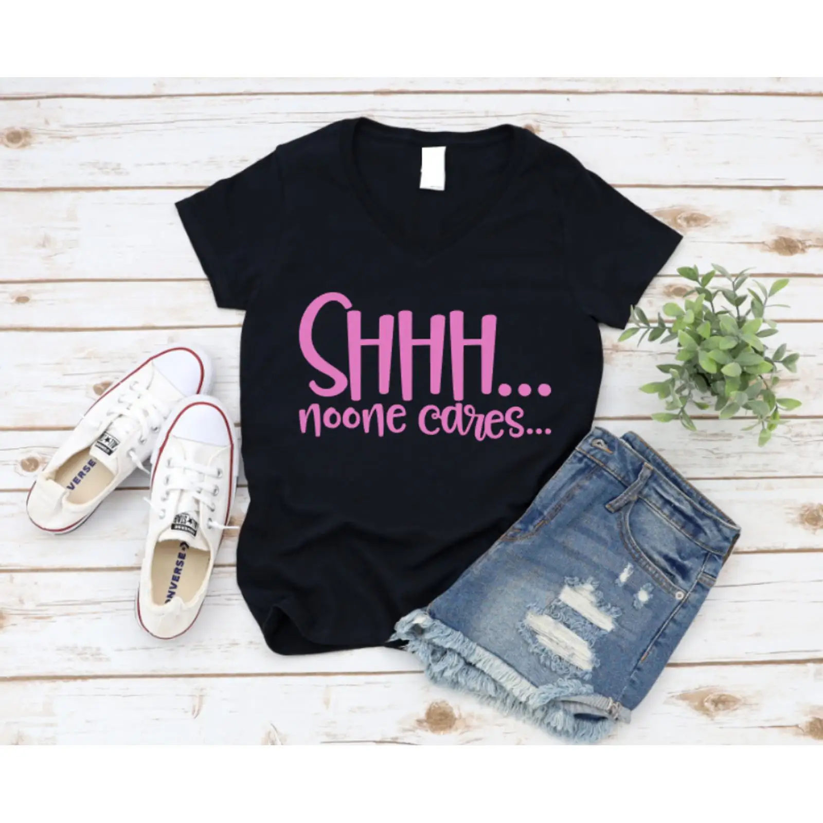 On Sneaker Care - 黒のTシャツにピンクの文字「SHHH noone cares」が描かれた木製の表面、スニーカーとショートパンツ、www missmafia com ヴィンテージ